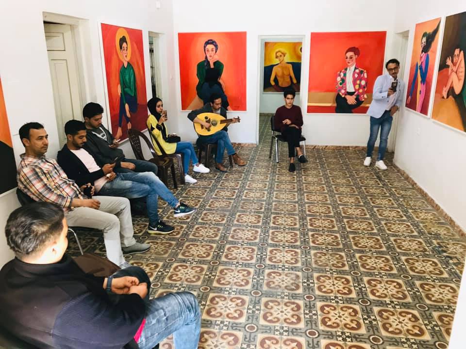 People sitting in circle in a room at a gallery opening