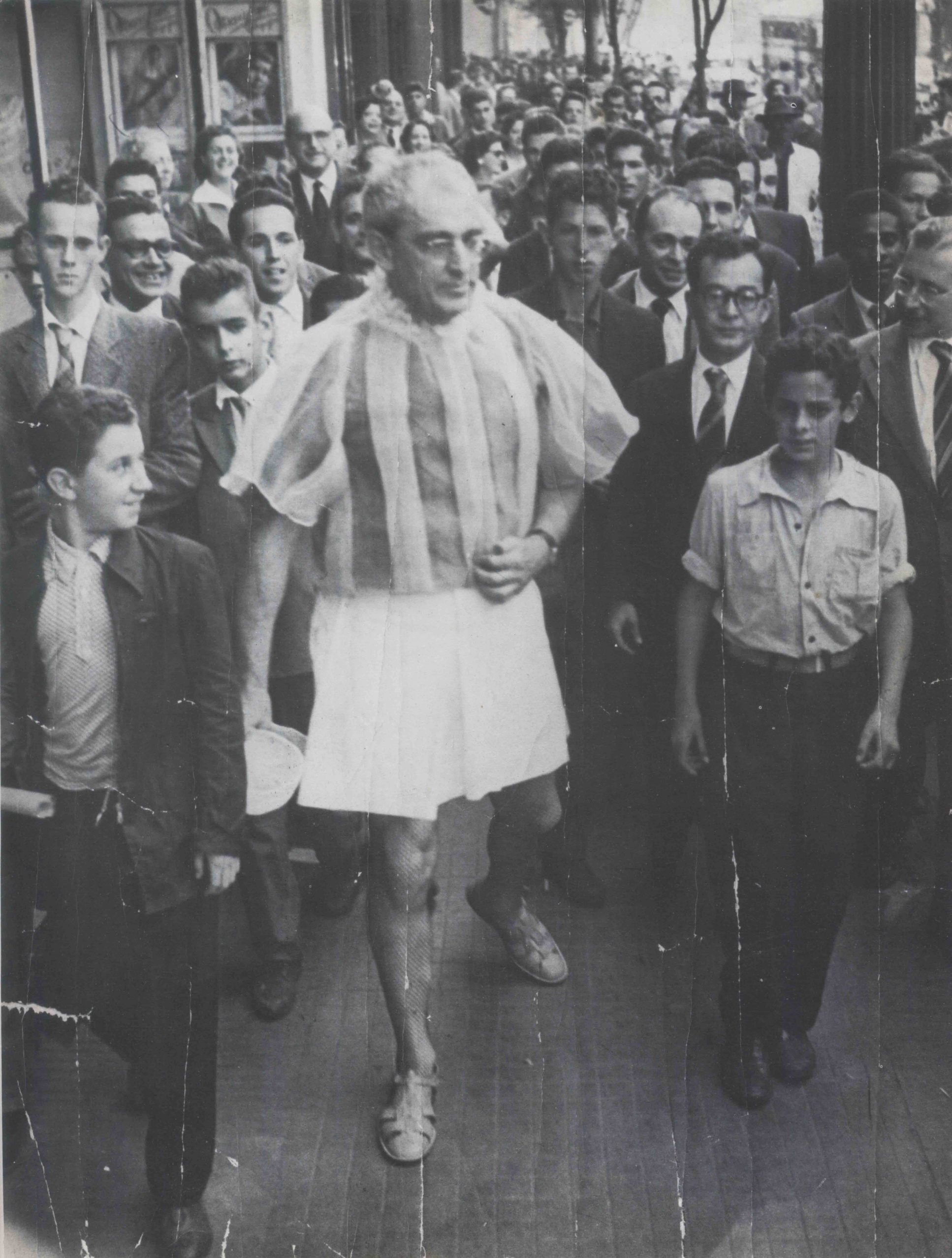 Flàvio in a stripy shirt and white shorts in the middle of crowd of people. Black and image photograph