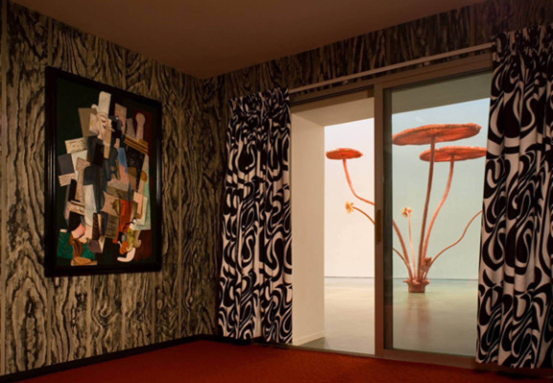A room with a red carpet, a painting on the wall, and a human size mushroom visible in the background.
